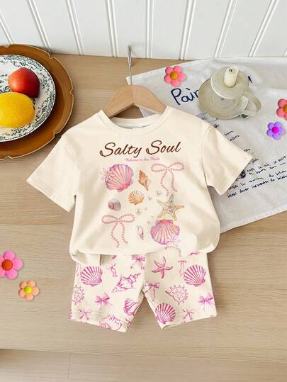 SHEIN 女婴奶油色 Salty Soul 图案T恤和短裤套装（2件套），饰有海星、贝壳、珍珠和蝴蝶结图案，休闲简约的短袖圆领T恤和短裤，适合春夏日常穿着、街头风、度假、返校季等场合。