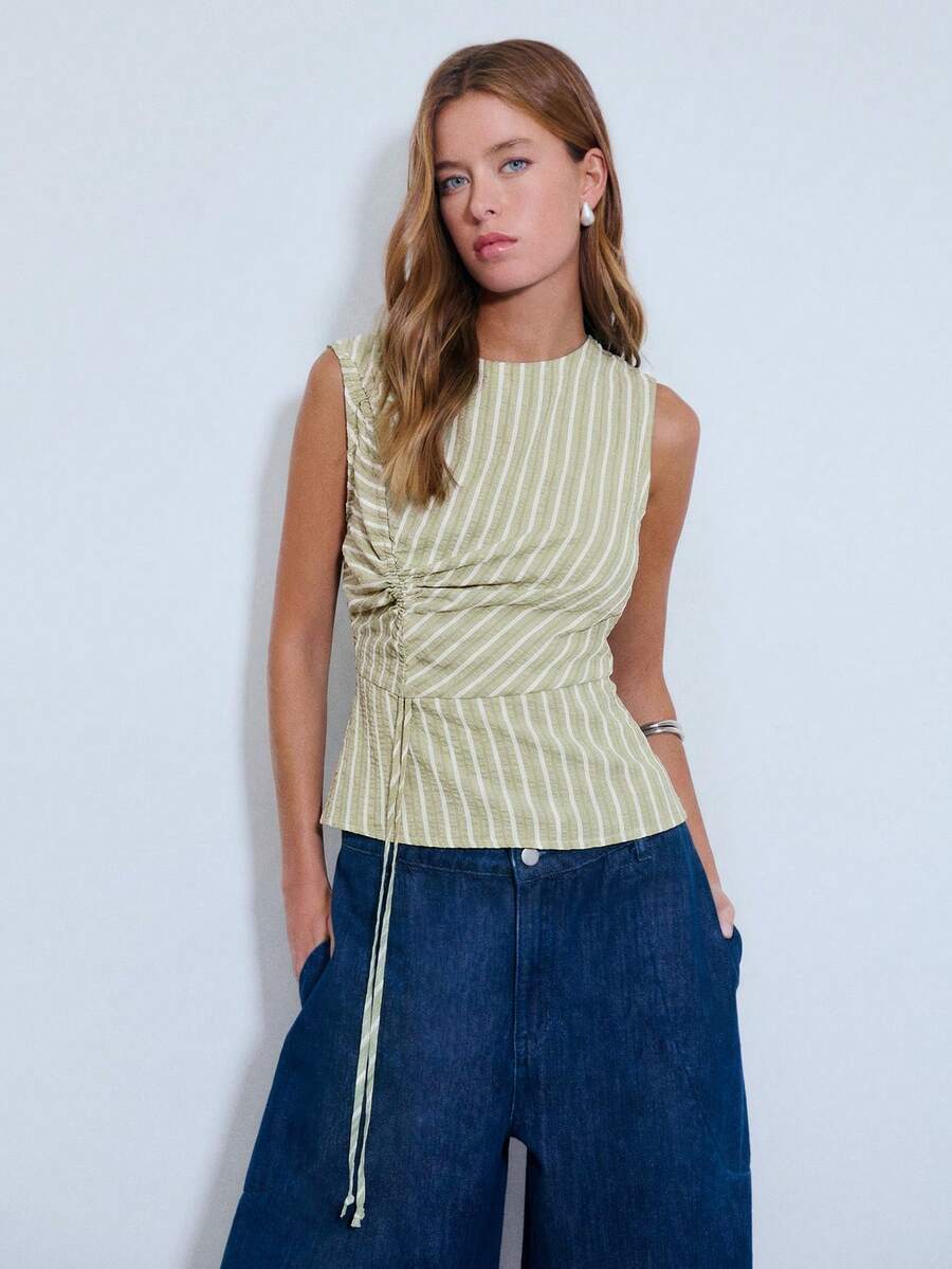 Áo không tay bằng vải kẻ sọc xanh dương, có phần nhún bèo điều chỉnh được ở phía trước, khóa kéo bên hông và cổ tròn. Thích hợp cho mùa hè, mùa xuân, mặc thường ngày, đi nghỉ mát. - màu xanh lá - Xem 1