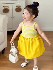 SHEIN Playful Pals 女婴吊带A字连衣裙。这款连衣裙采用吊带设计，简约优雅。A字裙摆更添活泼可爱之感。宽松版型适合各种身材。适合夏季海滩度假、户外野餐以及休闲外出等活动，让宝宝在享受轻松自由时光的同时，展现她们独特的魅力。 - 黃色 - 查看 6