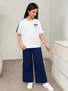 SHEIN Bộ đồ thể thao 2 món cho bé gái tuổi teen, kiểu dáng retro, tay raglan rộng thùng thình, phối màu tương phản, in nơ, cổ tròn và quần nỉ ống đứng, màu xanh & trắng. - Xanh và trắng - Xem 3