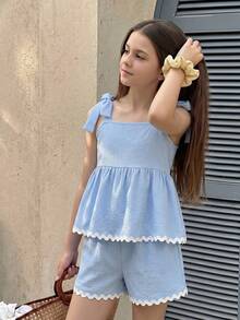 SHEIN Sparklyn 这款浅蓝色纹理两件套夏季女童套装，包括一件荷叶边露背上衣，饰有蕾丝蝴蝶结肩带，以及一条松紧腰短裤。采用轻盈面料制成，宽松的A字廓形，非常适合日常休闲穿着和玩耍。 - 淺藍色 - 查看 6