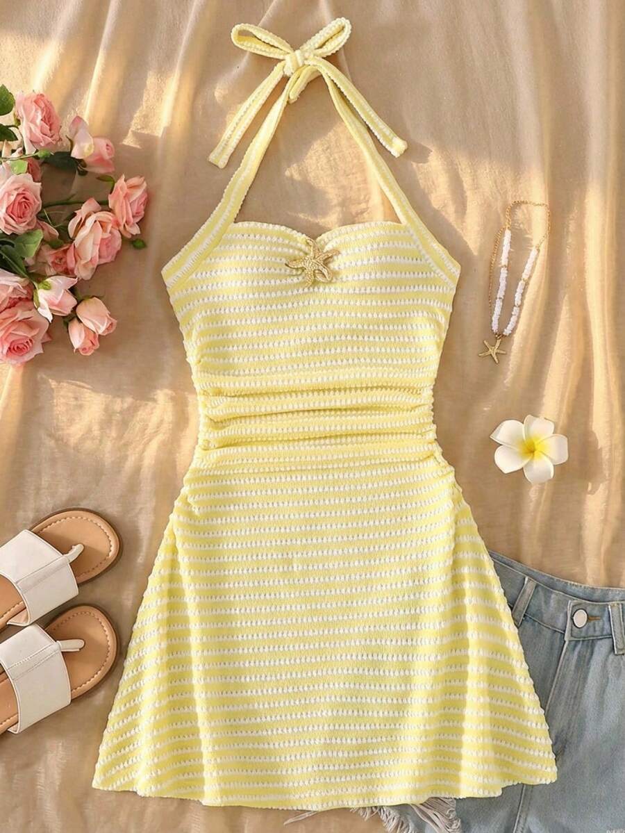 SHEIN Đầm cổ yếm màu vàng kẻ sọc dành cho bé gái tuổi teen, thiết kế hở vai, trang trí sao biển kim loại màu vàng, chất vải mềm mại phù hợp cho mùa hè, họa tiết tinh tế phù hợp cho các dịp hàng ngày và giao lưu nhẹ nhàng, thanh lịch và thoải mái, dễ phối đồ và bảo quản, tạo nên vẻ ngoài ngọt ngào và dịu dàng cho bé gái. - Màu vàng - Xem 1