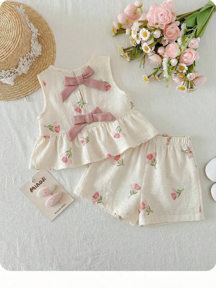 Bộ đồ bé gái dễ thương đi nghỉ mát, họa tiết hoa, trang trí nơ, gồm áo hai dây và quần cạp chun. - trắng - Xem 1