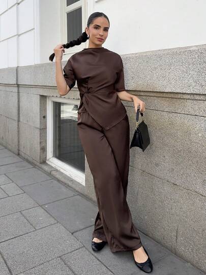 Marta Soriano Bộ đồ nữ 2 món màu nâu trơn mới về, gồm áo cổ cao không tay màu sô cô la với chi tiết xoắn và quần ống rộng cạp cao.