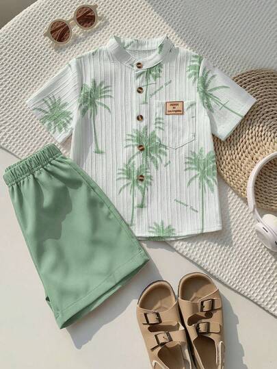 SHEIN Genkimix Kids Bộ 2 món áo sơ mi cổ bẻ in hình cây dừa và chữ cái có túi cùng quần short màu trơn dáng casual dành cho bé trai, thích hợp cho các chuyến đi chơi, kỳ nghỉ và nhiều dịp khác nhau.