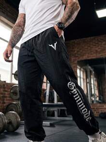 GymBeat Quần thể thao nam in chữ, có túi, cạp chun, dây rút - màu đen - Xem 1