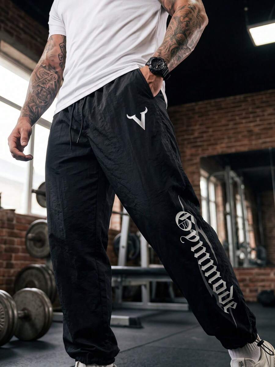 GymBeat Quần thể thao nam in chữ, có túi, cạp chun, dây rút - màu đen - Xem 1