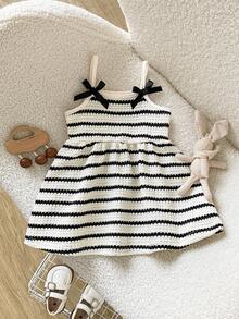 SHEIN Playful Pals 女婴吊带A字连衣裙。这款连衣裙采用吊带设计，简约优雅。A字裙摆更添活泼可爱之感。宽松版型适合各种身材。适合夏季海滩度假、户外野餐等活动，也适合日常休闲穿着，让宝宝在享受轻松自由时光的同时，展现她们独特的魅力。 - 黑與白 - 查看 4