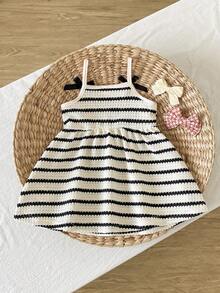 SHEIN Playful Pals 女婴吊带A字连衣裙。这款连衣裙采用吊带设计，简约优雅。A字裙摆更添活泼可爱之感。宽松版型适合各种身材。适合夏季海滩度假、户外野餐等活动，也适合日常休闲穿着，让宝宝在享受轻松自由时光的同时，展现她们独特的魅力。 - 黑與白 - 查看 3