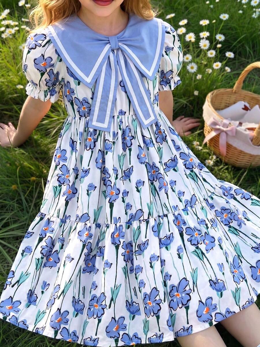 这款女童夏季波西米亚风甜美度假连衣裙，采用蓝色碎花印花，配有大蝴蝶结领、短袖和宽松的及膝裙摆。非常适合日常穿着、购物、海滩郊游、度假等场合。