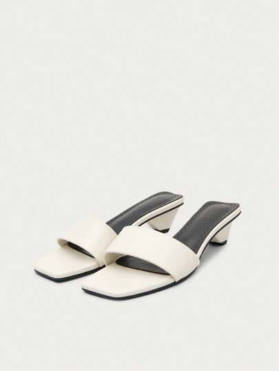 Nöista Một đôi sandal gót thấp thời trang màu kem bóng bẩy, với quai trước rộng tạo nên vẻ ngoài vừa trẻ trung vừa thanh lịch.