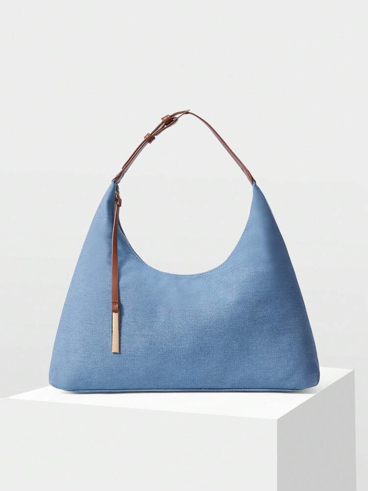 A STYLISH AND MINIMALIST SHOULDER BAG WITH A DELICATE METAL PENDANT IS SUITABLE FOR COMMUTING AND SHOPPING.