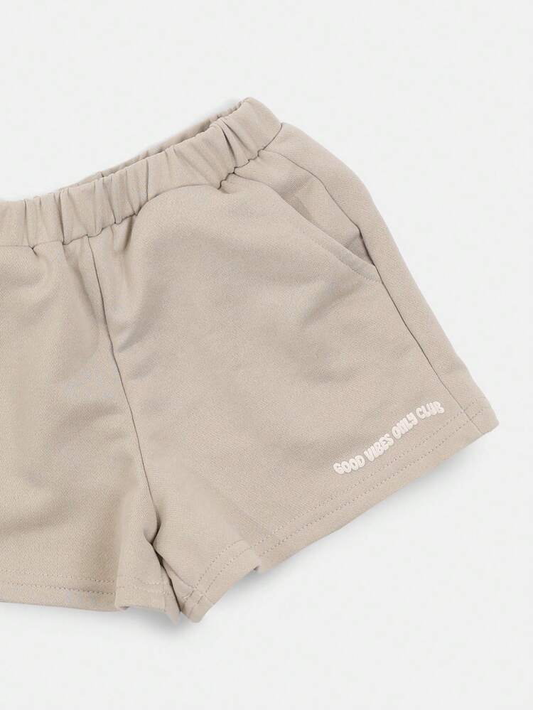 Ensemble coordonné t-shirt vert sauge surdimensionné et shorts avec impression de texte rose "Good Vibes Only Club Era 23". Tenue d'été décontractée pour filles