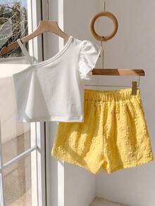 SHEIN Bộ đồ đôi thanh lịch cho bé gái tuổi teen, phong cách nghỉ dưỡng ngọt ngào, phối màu độc đáo: Áo trắng cổ lệch với họa tiết hoa 3D và hạt ngọc trai ở giữa, áo ôm sát bằng vải gân, quần short vàng cạp chun với họa tiết hoa dập nổi, chất liệu mỏng mềm mại, phù hợp cho tiệc tùng, dã ngoại, đi học, khiêu vũ, mặc hàng ngày, mùa xuân và mùa hè. Bộ đồ trẻ em đa năng và đáng yêu. - Màu vàng - Xem 2