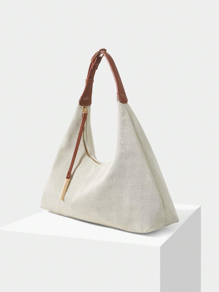 A STYLISH AND MINIMALIST SHOULDER BAG WITH A DELICATE METAL PENDANT IS SUITABLE FOR COMMUTING AND SHOPPING.