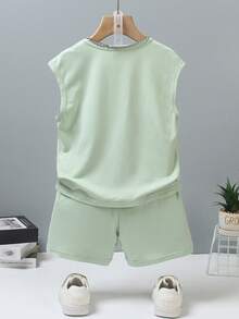 SHEIN Genkimix Kids Bộ quần áo không tay cho bé trai theo phong cách đường phố Mỹ, gồm áo ba lỗ và quần short, thiết kế đơn giản và thoải mái, phù hợp cho các hoạt động thể thao mùa hè hoặc mặc thường ngày. Áo ba lỗ có màu xanh bạc hà với chữ nổi "LOS ANGELES" và "CALIFORNIA" in nổi, tạo nên vẻ ngoài nhiều lớp và thời trang. Quần short cũng có chữ in nổi. - Màu xanh Bạc hà - Xem 2