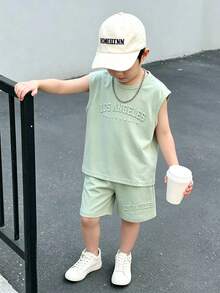 SHEIN Genkimix Kids Bộ quần áo không tay cho bé trai theo phong cách đường phố Mỹ, gồm áo ba lỗ và quần short, thiết kế đơn giản và thoải mái, phù hợp cho các hoạt động thể thao mùa hè hoặc mặc thường ngày. Áo ba lỗ có màu xanh bạc hà với chữ nổi "LOS ANGELES" và "CALIFORNIA" in nổi, tạo nên vẻ ngoài nhiều lớp và thời trang. Quần short cũng có chữ in nổi. - Màu xanh Bạc hà - Xem 3