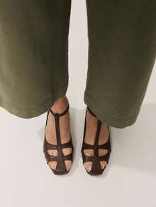 Mẫu sandal đế bằng cổ điển bằng da màu nâu, thiết kế quai chữ T với mũi kín và khóa điều chỉnh ở mắt cá chân, tạo nên vẻ ngoài thanh lịch vượt thời gian. - Cà phê nâu - Xem 1