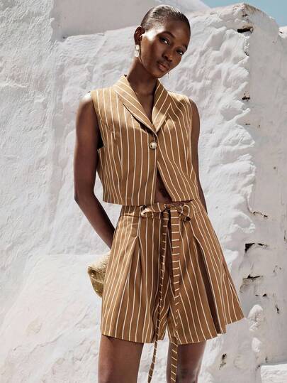 Aveloria Modichic Bộ 2 món kiểu sinh viên gồm áo crop top không tay cổ bẻ kèm thắt lưng và chân váy xếp ly ngắn dành cho nữ.