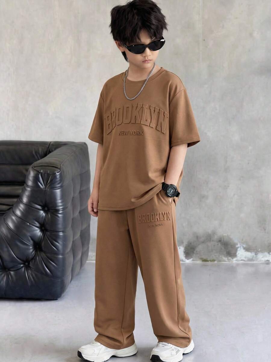 SHEIN 2pcs/Set Tween Boys' Brown Summer Casual City Break College Style Big Letter Embossed Graphic Round Neck Short Sleeve T-Shirt And Pants Sports Set - Coffee Brown - View 1