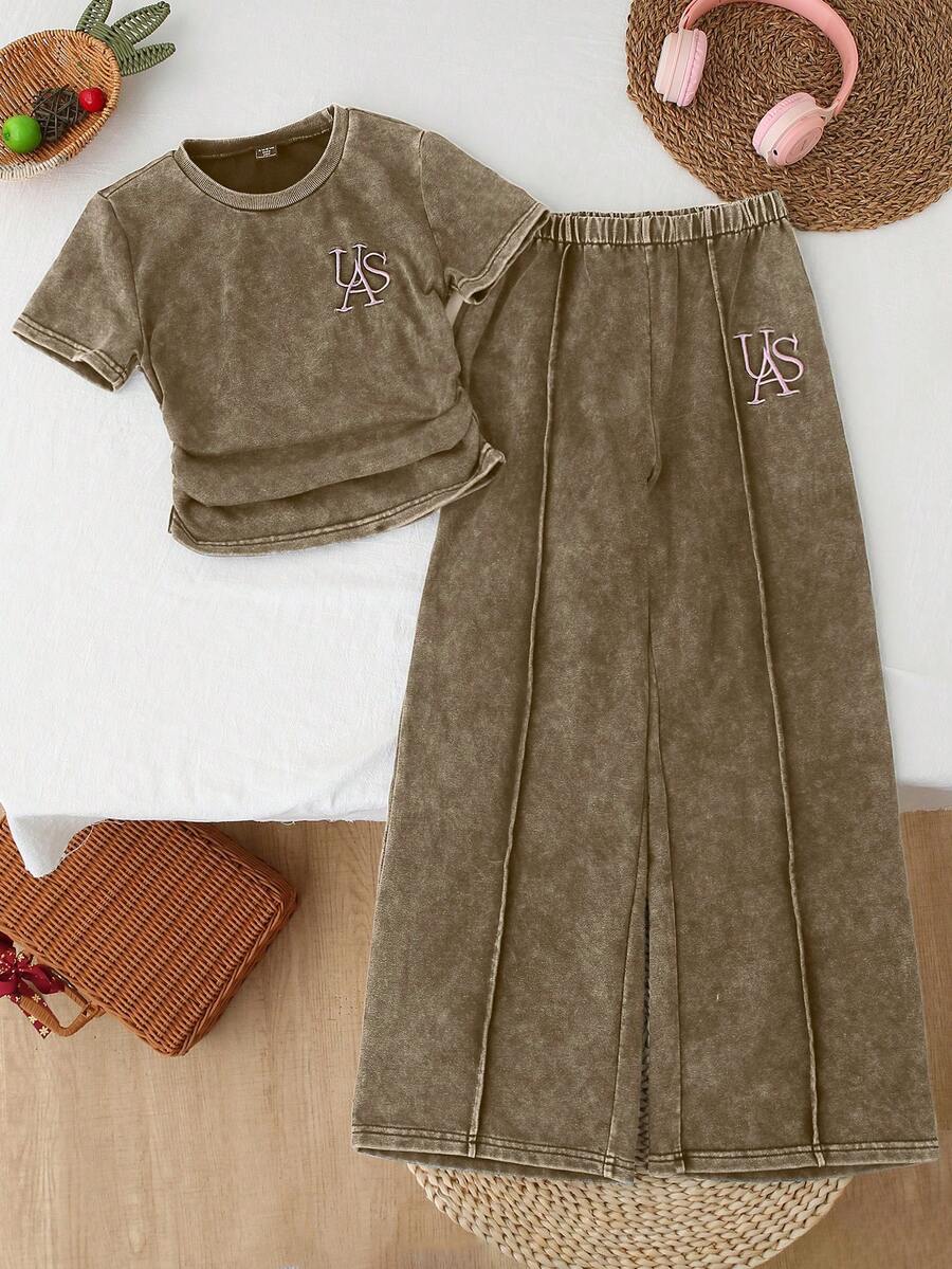 SHEIN Conjunto de camiseta casual para niñas preadolescentes 2026. Estilo de moda relajado. Técnica de lavado en tie-dye marrón, bordado en inglés lindo. Cintura elástica. Acento de costura vertical. Corte holgado. Tejido de efecto denim suave y ligero, cómodo y amigable con la piel. Esencial para niñas preadolescentes de moda. Casual minimalista, adecuado para uso en verano, salidas diarias, fiestas, festivales de música, vacaciones y talla grande ocasiones.
