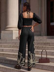 CAJUNI Damen Urlaubs-Set aus einfarbigem Laternenhülsen-Crop-Trägertop mit Hohlmuster und Hose mit Blume Muster - Schwarz - Übersicht 2