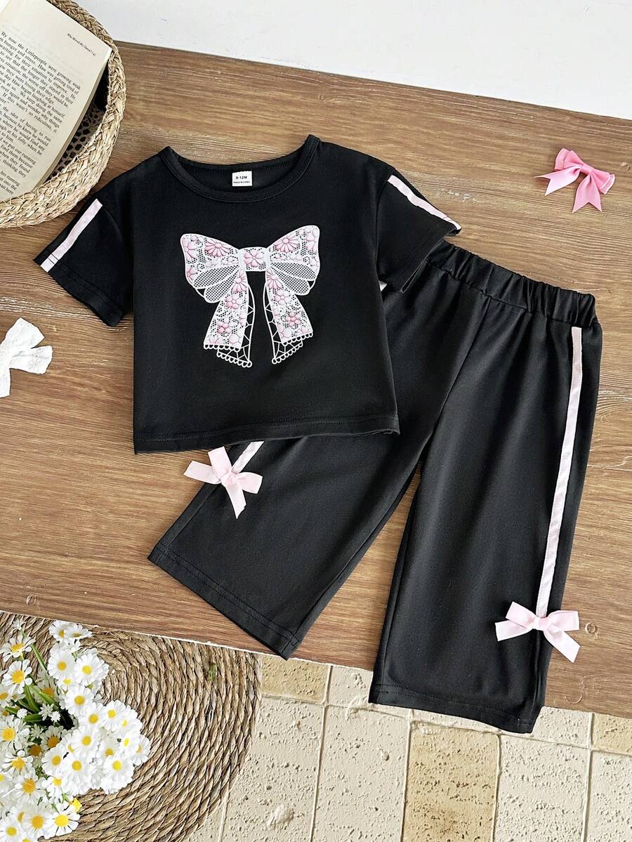 SHEIN 两件套女童夏季休闲甜美优雅街头风套装,黑色圆领T恤胸前饰有粉色蝴蝶结印花,搭配黑色长裤,适合上学和日常穿着。 - 黑色 - 查看 1