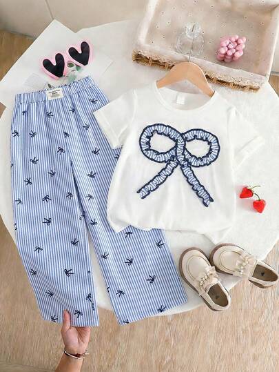 2026 Summer New Girls' Fresh Blue & White Bow 2 Pieces Set, Featuring A Simple White T-Shirt Paired With A 3D Blue & White Striped Big Bow Accent, Complemented By Blue & White Vertical Striped Wide-Leg Pants With All-Over Mini Bow Prints, Elastic Waistband For Comfortable Fit, Loose And Draping Style To Flatter The Legs. The Coordinated Design Elements Make This Set Easy To Style For Daily Outings, School, Family Trips, And Hangouts With Friends.
