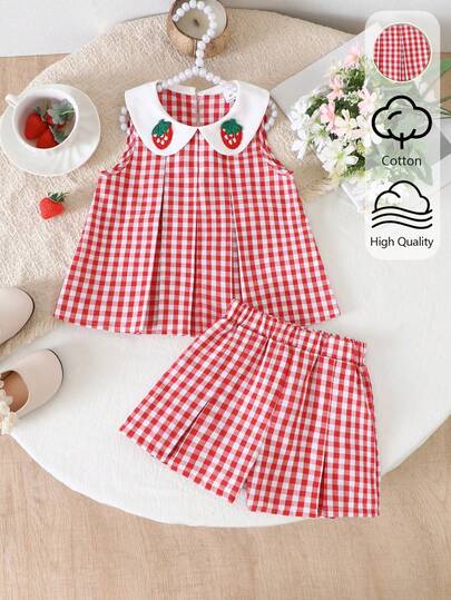 SHEIN Elladie kids 女童红白拼接草莓图案无袖上衣+短裤套装。经典的红白拼接梭织面料，白色彼得潘领饰以可爱的草莓图案，上衣采用修身褶皱设计。面料柔软舒适，搭配同色休闲短裤，适合打造可爱夏日造型，是派对、上学、度假、拍照的理想之选。兼具实用时尚、海岛风情、海滩周末休闲和夏季穿着的风格。