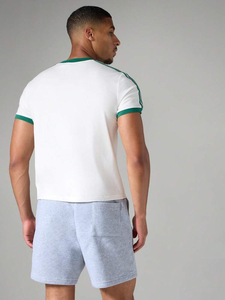 Retro Ringer Rundhals Kurzarm T-Shirt mit kontrastierendem grünem Streifendetail und Logo-Muster