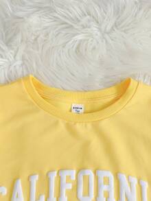 SHEIN Bộ đồ 2 món cho bé gái và thiếu niên, màu xám, chất liệu dệt kim, dáng rộng, in khẩu hiệu tiếng Anh Mỹ, cổ tròn, tay ngắn và quần short in họa tiết, thích hợp cho mùa hè và thể thao đường phố. - Màu vàng - Xem 3