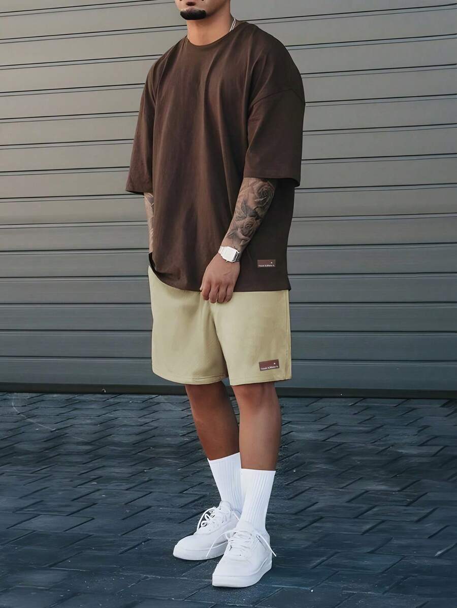 Manfinity Homme Conjunto de camiseta de manga corta y pantalones cortos deportivos de estilo callejero juvenil para hombres, para festivales de música y atuendos diarios, regalo para novios o esposos, que refleja el estilo streetwear y Y2K, conjuntos de dos piezas para hombres, conjunto de top de manga corta estampado y pantalones cortos para hombres, atuendos cómodos - Multicolor - Ver 1