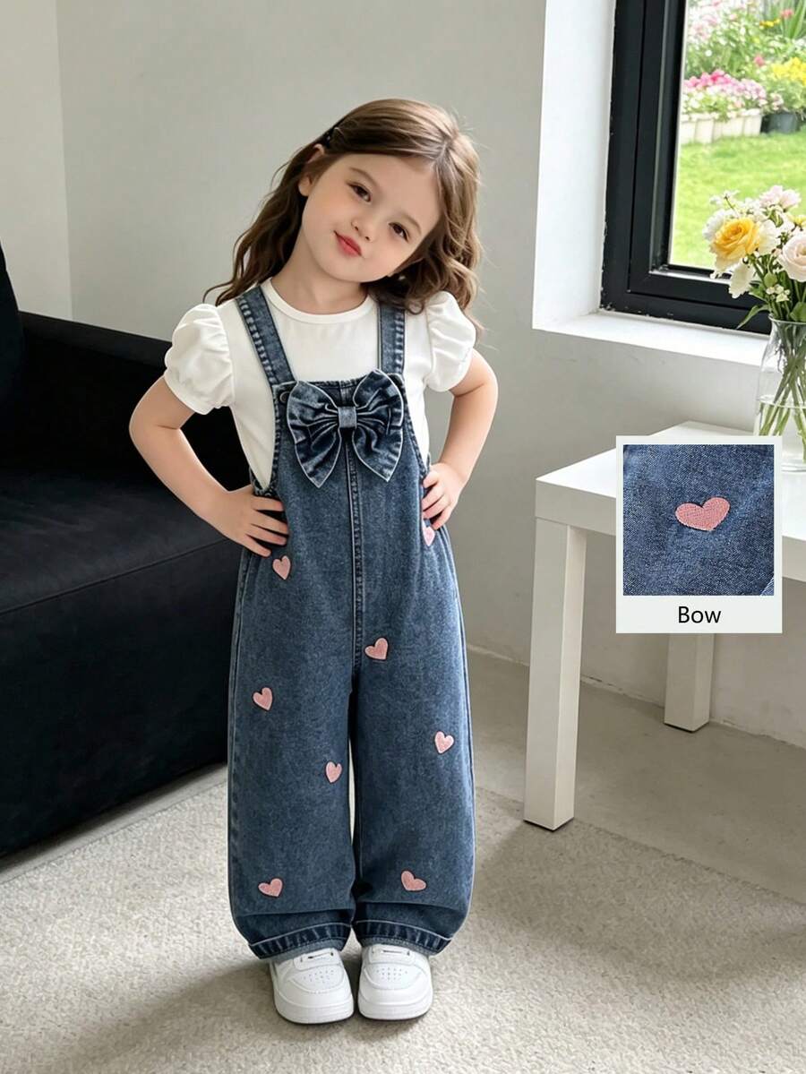 SHEIN Genkimix Kids بناطيل ساحرة للفتيات الصغيرات من الجينز، مناسبة للربيع/الصيف/الخريف/الشتاء، لون الجينز الأزرق المتوسط الرجعي، بتطريز قلب وردي للمظهر الجذاب، زخرفة فيونكة كبيرة على الصدر، ساق مستقيمة فضفاضة، قماش ناعم ومريح، مناسب للخروجات اليومية والمدرسة