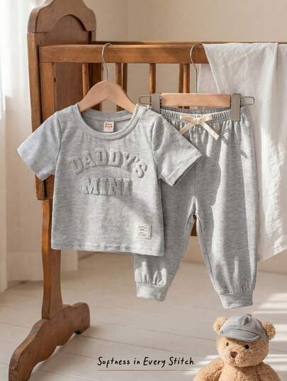 Cozy Pixies Bộ 2 món cho bé trai gồm áo thun cổ tròn tay ngắn và quần cạp chun in chữ, chất liệu mềm mại.