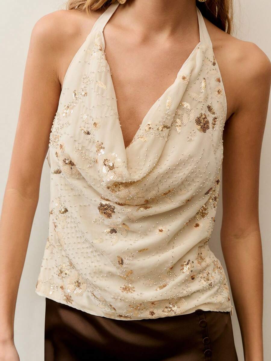 Nöista Áo quây màu trắng kem đính sequin được làm từ chất liệu thoáng khí với những nếp gấp thanh lịch, hoàn hảo cho các bữa tiệc, buổi hẹn hò và kỳ nghỉ xuân hè. Có thể mặc riêng như một món đồ nổi bật hoặc phối cùng chân váy hoặc quần cạp cao để tạo nên vẻ ngoài tinh tế. - Rượu sâm banh - Xem 1