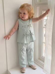 SHEIN Bộ đồ thể thao cho bé gái màu hồng và xanh lá cây trơn, kiểu dáng tối giản với nơ 3D trang trí, gồm áo không tay và quần dài, thích hợp mặc hàng ngày và đi nghỉ mát, mùa xuân/hè. - màu xanh lá - Xem 4