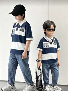 2件組小男孩校園 Polo 衫與牛仔褲套裝，春夏款。Polo 衫為海軍藍色，配白色領口與 2 顆鈕扣，簡約俐落設計，右側附小口袋。牛仔褲為淺藍色，經典百搭。整體風格清新休閒，適合兒童日常活動如上學或戶外玩耍。 - 彩色 - 查看 4
