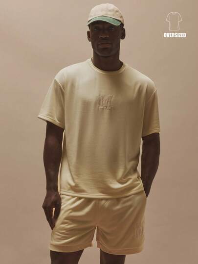 Musero Camiseta de cuello redondo oversize de manga corta con hombros caídos, con parche con emblema de marca en el pecho central, esencial para primavera y verano, ideal para vacaciones