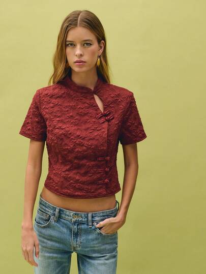 Nöista Top de jacquard inspirado en lo chino en un profundo tono borgoña con cierres de botones de rana tradicionales y un elegante cuello alto con un sutil detalle de recorte. Diseñado en una tela con textura floral y un ajuste estructurado, perfecto para looks de verano para salir, atuendos elegantes casuales, cenas, estilo de vacaciones, moda Y2K o atuendos primaverales y de festival.