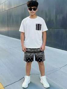 SHEIN Bộ đồ thể thao cho bé trai tuổi teen, gồm áo thun trắng cổ tròn dáng rộng và quần short đen họa tiết hoa, thích hợp đi học, mặc hàng ngày, chơi thể thao, mùa xuân/hè. - Đen và trắng - Xem 1
