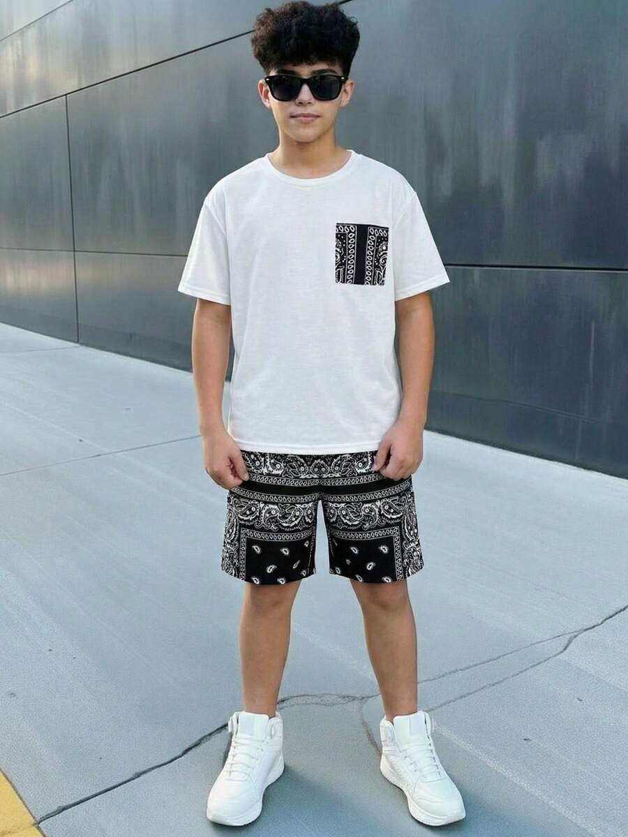 SHEIN Bộ đồ thể thao cho bé trai tuổi teen, gồm áo thun trắng cổ tròn dáng rộng và quần short đen họa tiết hoa, thích hợp đi học, mặc hàng ngày, chơi thể thao, mùa xuân/hè. - Đen và trắng - Xem 1