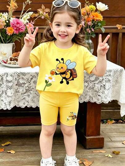 Bộ đồ thường ngày cho bé gái gồm áo thun ngắn tay cổ tròn in hình ong và quần short.