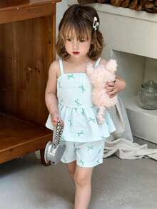 SHEIN Vintaside Kids 这款女童夏季粉白条纹露背吊带短裙套装，甜美俏皮，充满度假风情；采用梭织面料，版型合身。整套服装印满粉色小蝴蝶结和条纹图案，裙摆饰有荷叶边，活泼优雅。适合日常出行、上学、海滩度假、参加派对活动以及休闲放松等各种场合。 - 綠色 - 查看 5