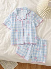 SHEIN Vintaside Kids 这款两件套女童夏季短袖睡衣，上衣采用翻领纽扣前襟设计。这款休闲家居服采用柔软顺滑的泡泡纱面料，饰以蓝白格纹图案、粉色撞色滚边、迷人的蝴蝶结印花和可爱的樱桃图案，营造出俏皮舒适的氛围。 - 藍色 - 查看 3