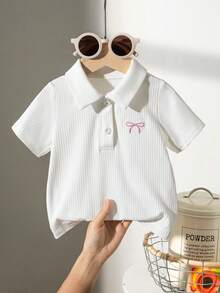 Souflis Souflis 这款女婴夏季魅力白色短袖Polo衫，采用实用百搭的亚麻罗纹面料，饰以粉色蝴蝶结刺绣图案，甜美简约的设计更添时尚感。柔软弹力的罗纹针织面料，精致的蝴蝶结刺绣和经典的Polo领，是夏季穿搭、早午餐约会、都市盛会、家庭聚会、上学日和休闲外出活动的理想之选。轻松搭配牛仔裤、裙子或背带裤，为您的宝贝公主打造优雅可爱的造型。 - 白色 - 查看 3