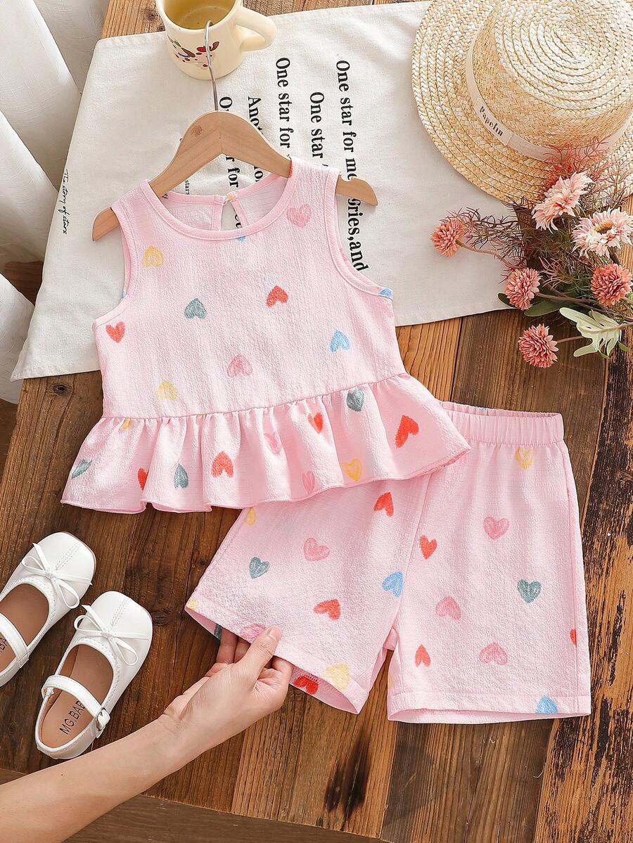 SHEIN Genkimix Kids Conjunto de verano para niñas de 4 a 7 años, estilo dulce y fresco, con top sin mangas con volantes y estampado de corazones de burbujas y arruga de agua, talla grande pantalón corto a juego estampado, de mezcla de algodón suave y ligera, adecuado para juegos al aire libre y uso diario casual en verano - Rosa - Ver 1