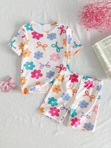 SHEIN Bộ đồ mặc nhà thoải mái cho bé gái, gồm áo thun cổ tròn ôm sát, họa tiết nơ và hoa hoạt hình dễ thương, gồm áo thun và quần short, họa tiết nơ và hoa. - Màu be - Xem 1