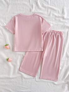 SHEIN 这款女宝宝春夏两件套包含一件粉色圆领短袖T恤和一条直筒裤。风格时尚、中性、甜美、活泼可爱，穿着舒适。采用宽松针织面料，正面饰有草莓印花，袖口和裤脚点缀白色蝴蝶结。适合日常外出、上学、运动、休闲放松以及参加聚会等各种场合。 - 粉色 - 查看 2