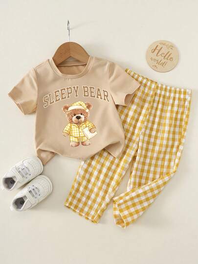 SHEIN Bộ đồ 2 món cho bé trai/bé gái in hình gấu dễ thương, gồm áo thun ngắn tay và quần kẻ caro vàng, thích hợp mặc ở nhà hoặc ngoài trời.