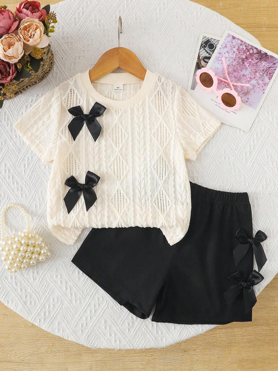 SHEIN 4-7岁女童休闲可爱日常套装,圆领宽松黑色丝带蝴蝶结装饰纹理面料短袖T恤,搭配3D蝴蝶结装饰和松紧腰短裤,适合夏季日常穿着、野餐、郊游、姐妹聚会等场合。 - 黑與白 - 查看 1